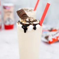 Kinder Bueno milkshake in a tall glass with a red straw