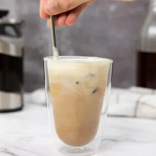 Mixing together the salted caramel cream cold brew with a reusable straw
