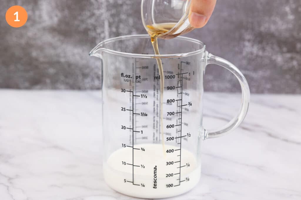 Pouring Starbucks vanilla syrup into a jug of cream and milk