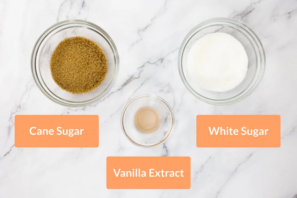 Cane sugar, white sugar and vanilla extract in glass bowls