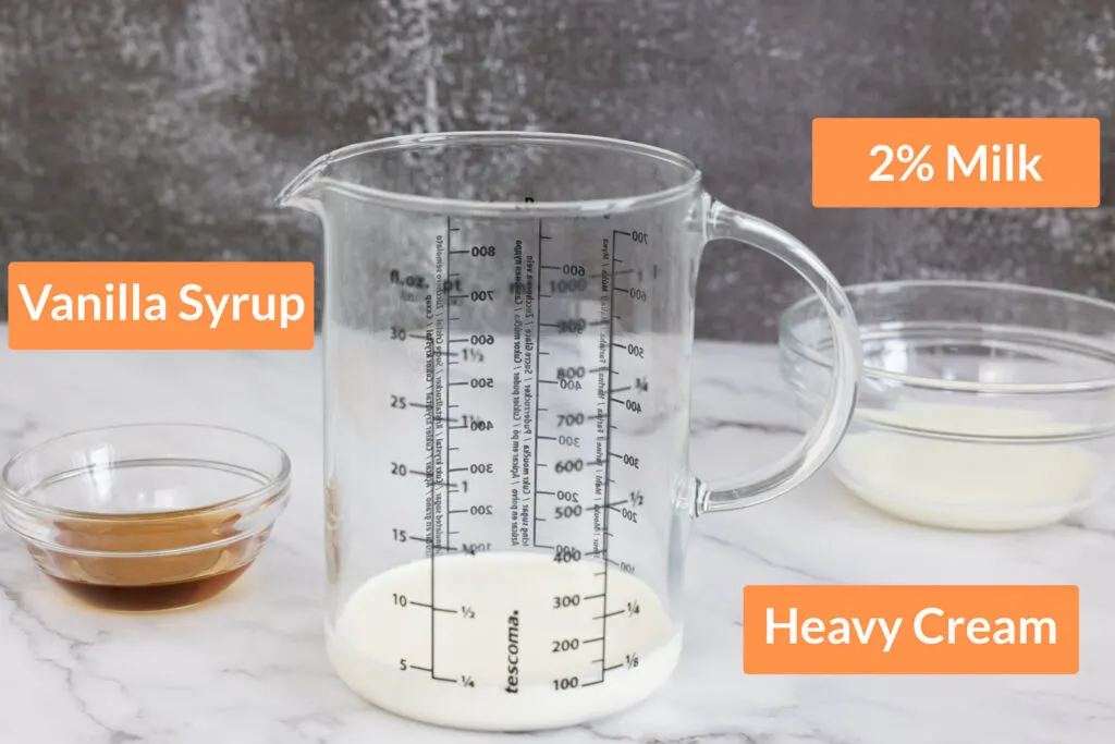 Vanilla sweet cream cold foam ingredients in bowls and a jug: 2% Milk, Heavy Cream, Vanilla Syrup