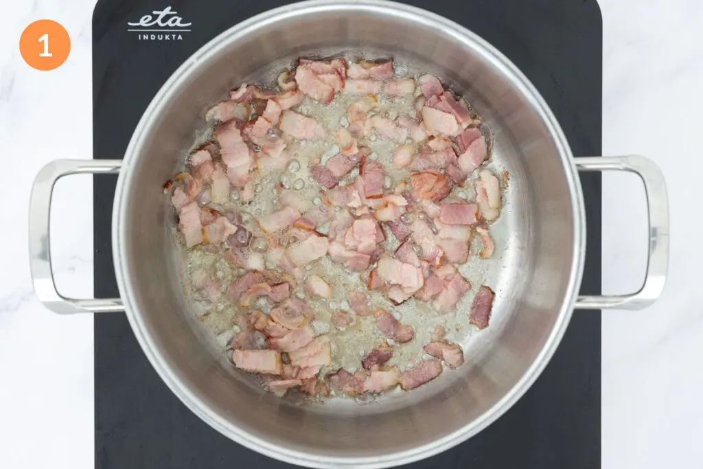Diced bacon frying in a large pot