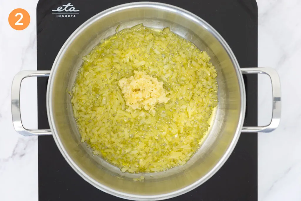 Softened onions and minced garlic slowly softening in a large pot