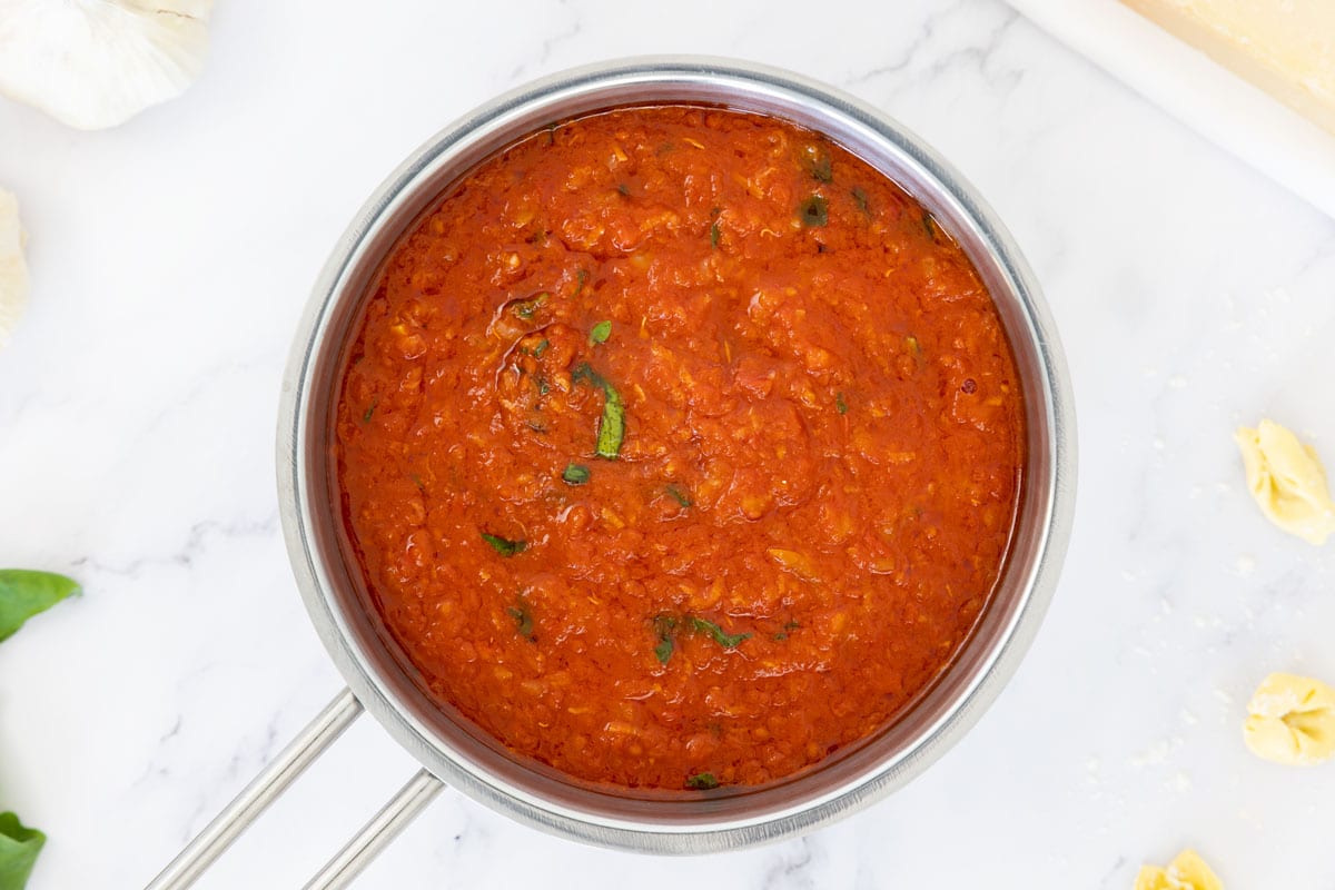 San Marzano tomato sauced with fresh basil in a saucepan