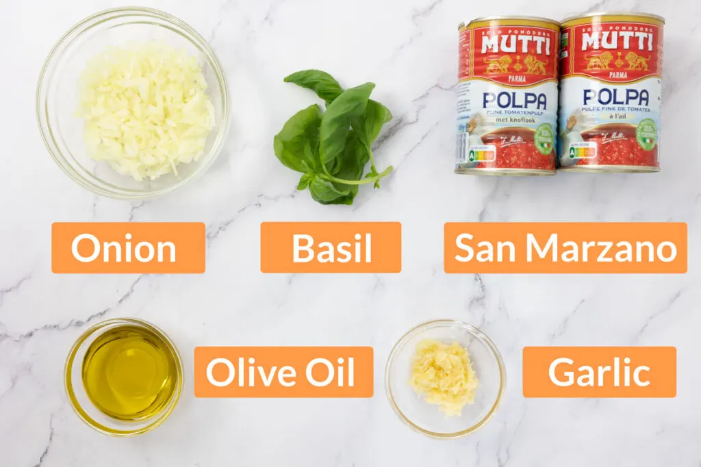 Ingredients for san marzano tomato sauce including onion, basil, San Marzano tinned tomatoes, olive oil and garlic