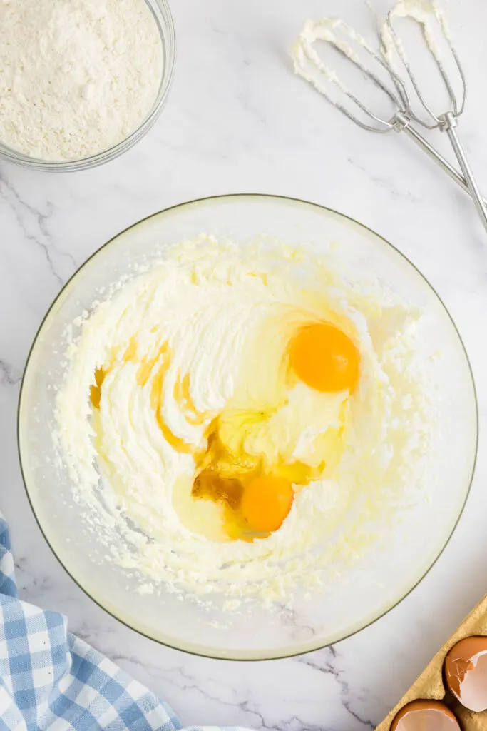 Eggs and vanilla extract added to creamed butter and granulated sugar
