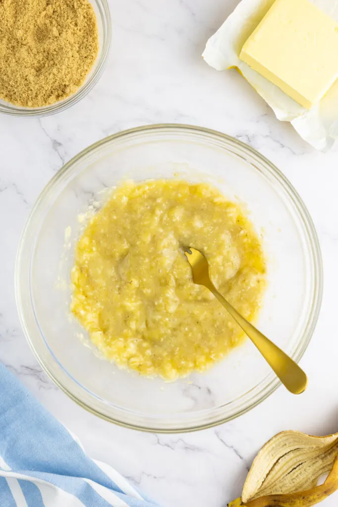 Mashed banana with a fork in a bowl
