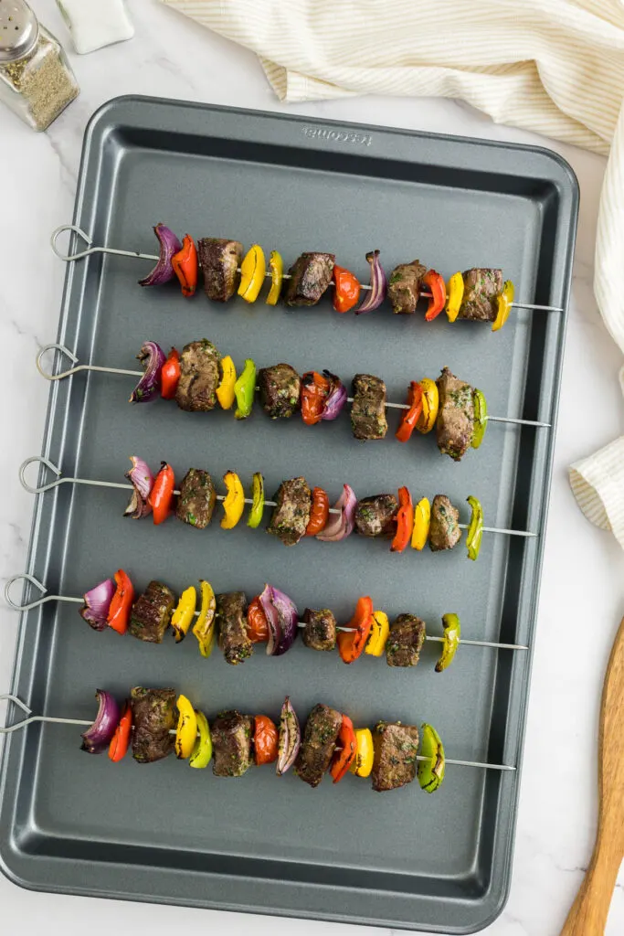 Beef kabobs that have been baked on a baking tray