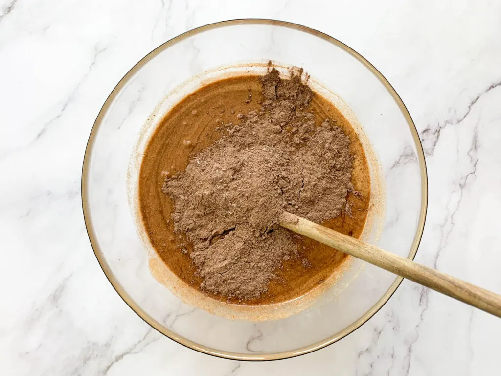 The dry ingredients (Cocoa, flour mix) being mixed into the chocolate batter