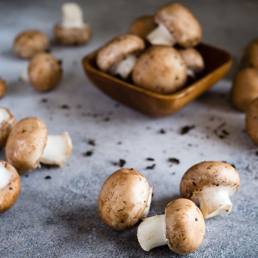 Cremini mushrooms scattered on a kitchen counter
