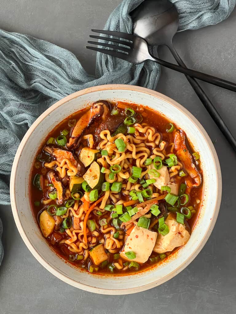 A bowl of ramen on a grey board