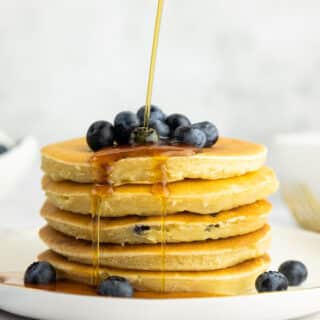 Buttermilk blueberry pancake stack with blueberries and maple syrup