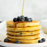 Buttermilk blueberry pancake stack with blueberries and maple syrup