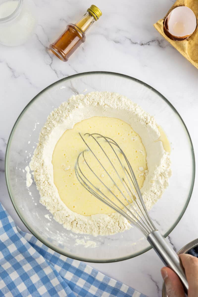 The dry ingredients being mixed with the wet ingredients in a bowl