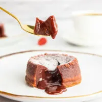 Picking up a piece of red velvet lava cake with a golden spoon