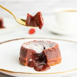 Picking up a piece of red velvet lava cake with a golden spoon