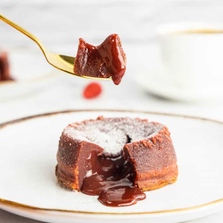 Picking up a piece of red velvet lava cake with a golden spoon
