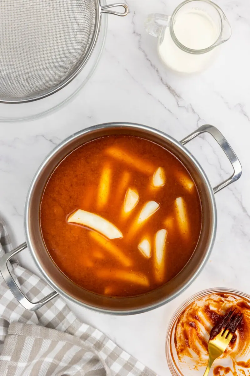 Adding Tteokbokki to the sauce