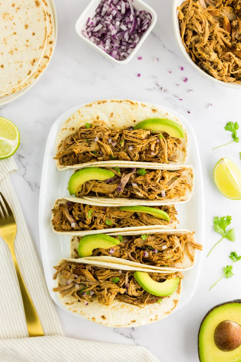 Taco de carnitas on a plate with avocado.