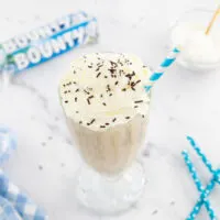 Bounty milkshake in a glass with a straw