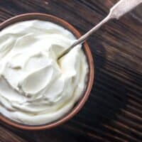 Creme Fraiche in a bowl on a wooden table.