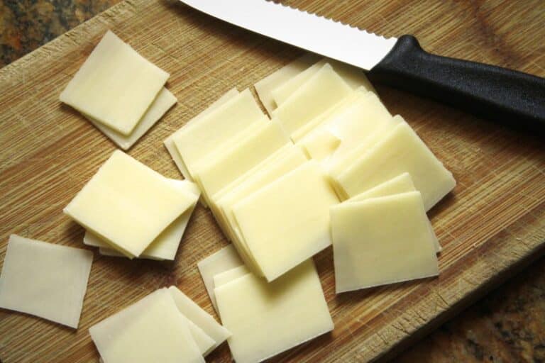 Monterey Jack cheese sliced on a chopping board.