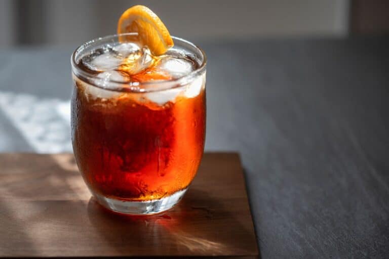 Vermouth in a glass with ice and a orange slice.