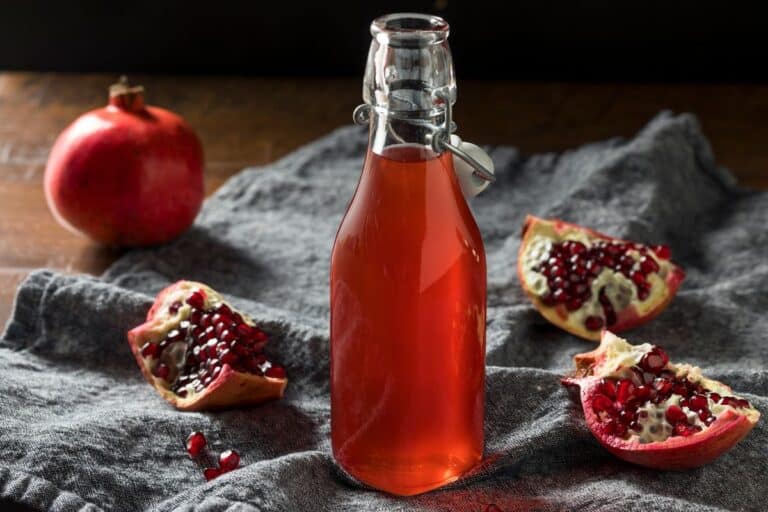 Grenadine in a bootle next to pomegranates