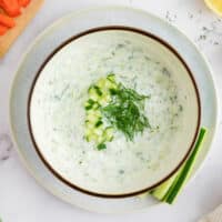 Homemade Tzatziki sauce in a bowl with sliced vegetables.