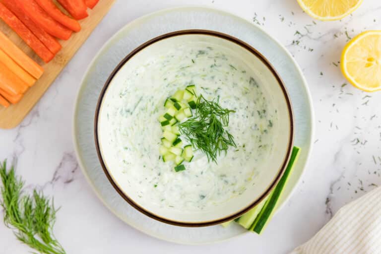 Homemade Tzatziki sauce in a bowl with sliced vegetables.