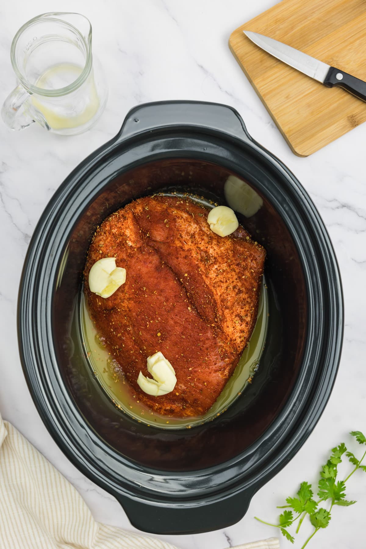Pork in a slow cooker with garlic and orange juice.