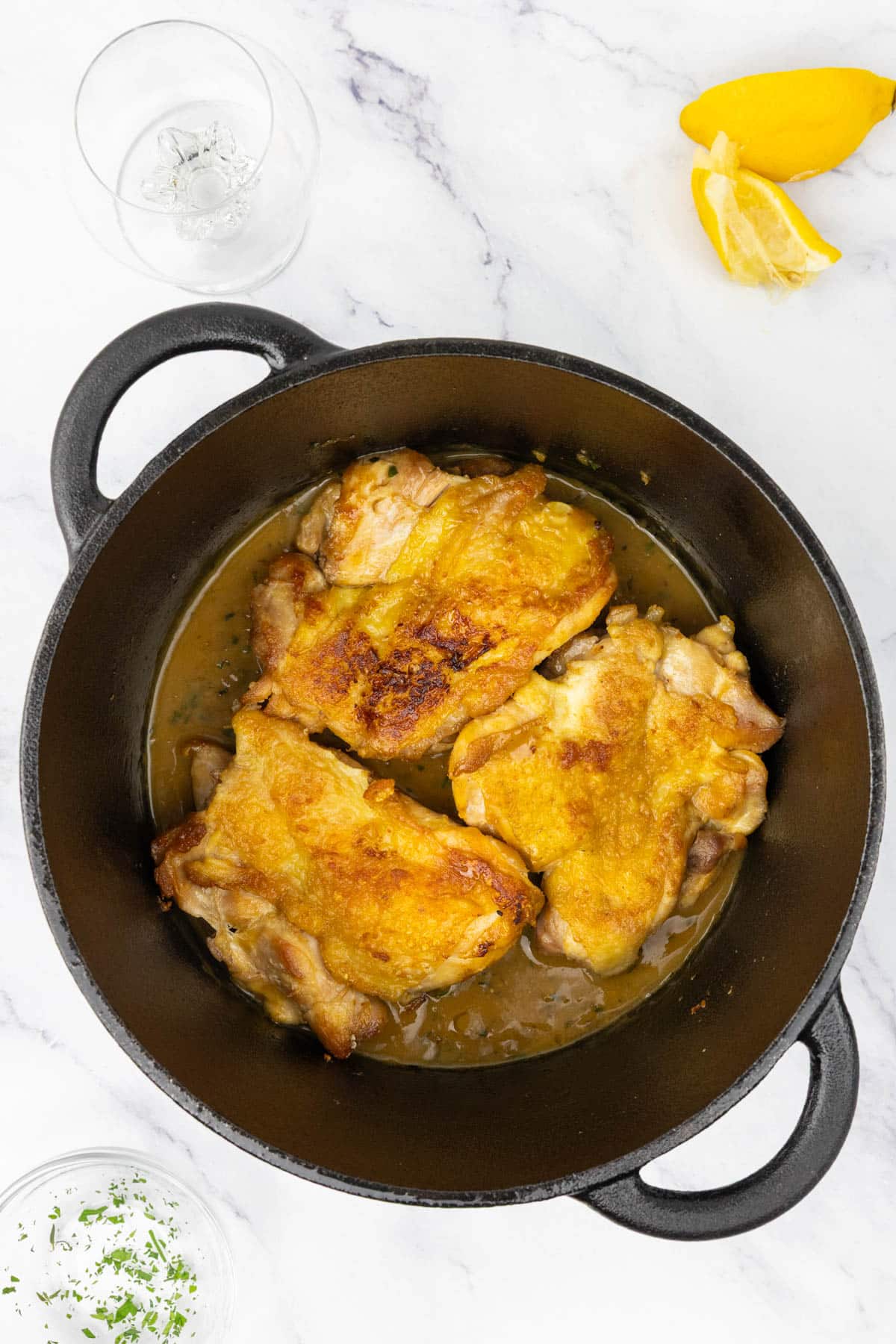 Chicken and a pan sauce in a pan.