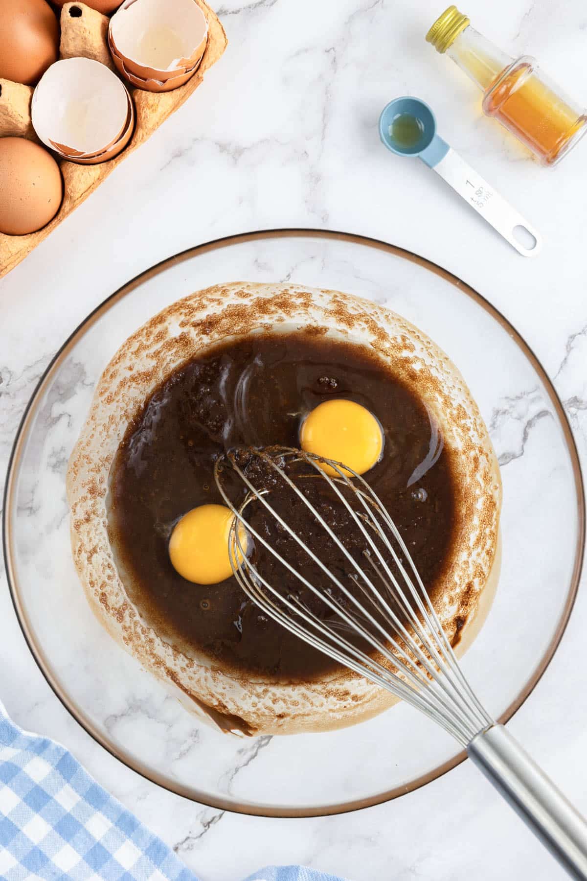 Eggs being whisked into melted chocolate.