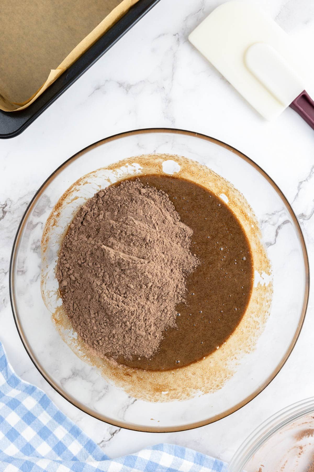 Cocoa and flour mixture being added to the brownies wet ingredients.