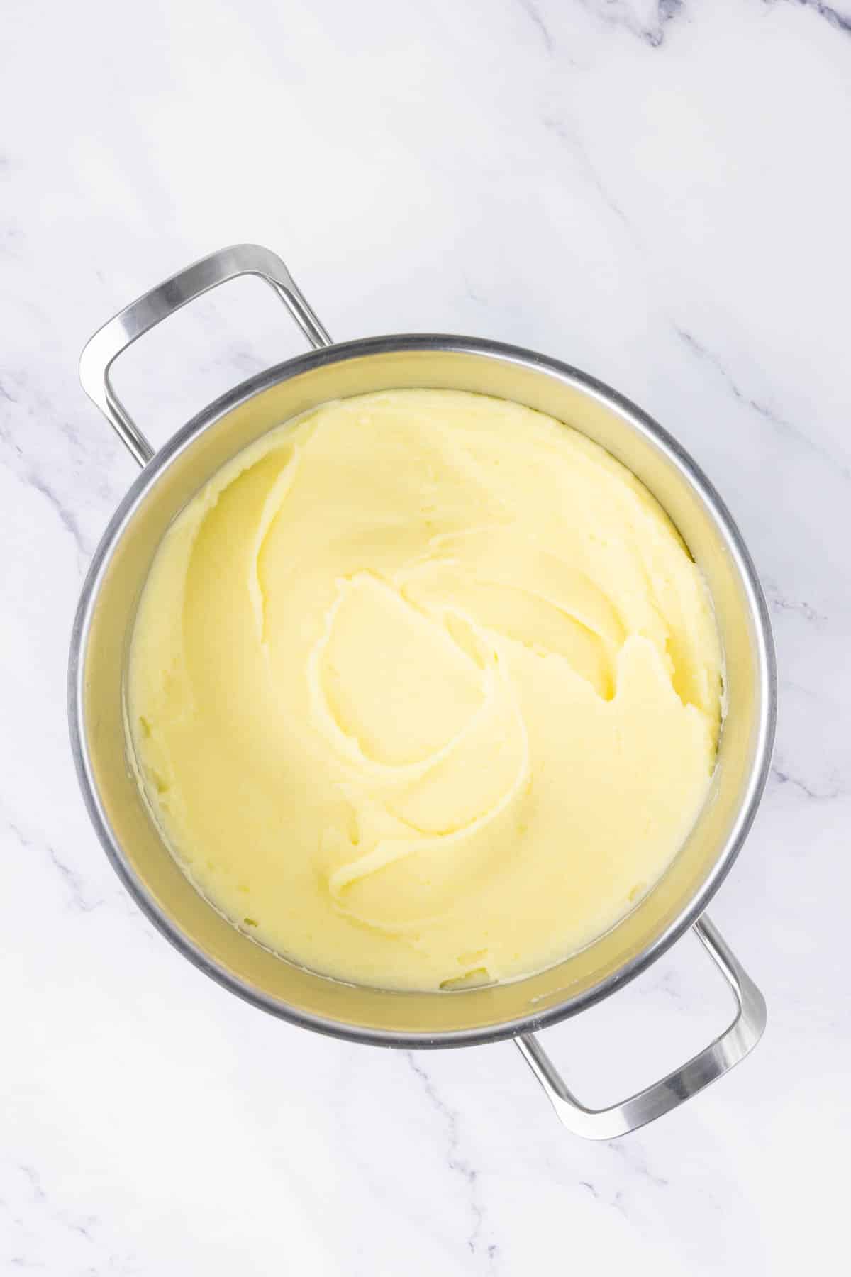 Smooth, creamy and butter mashed potatoes in a pot.