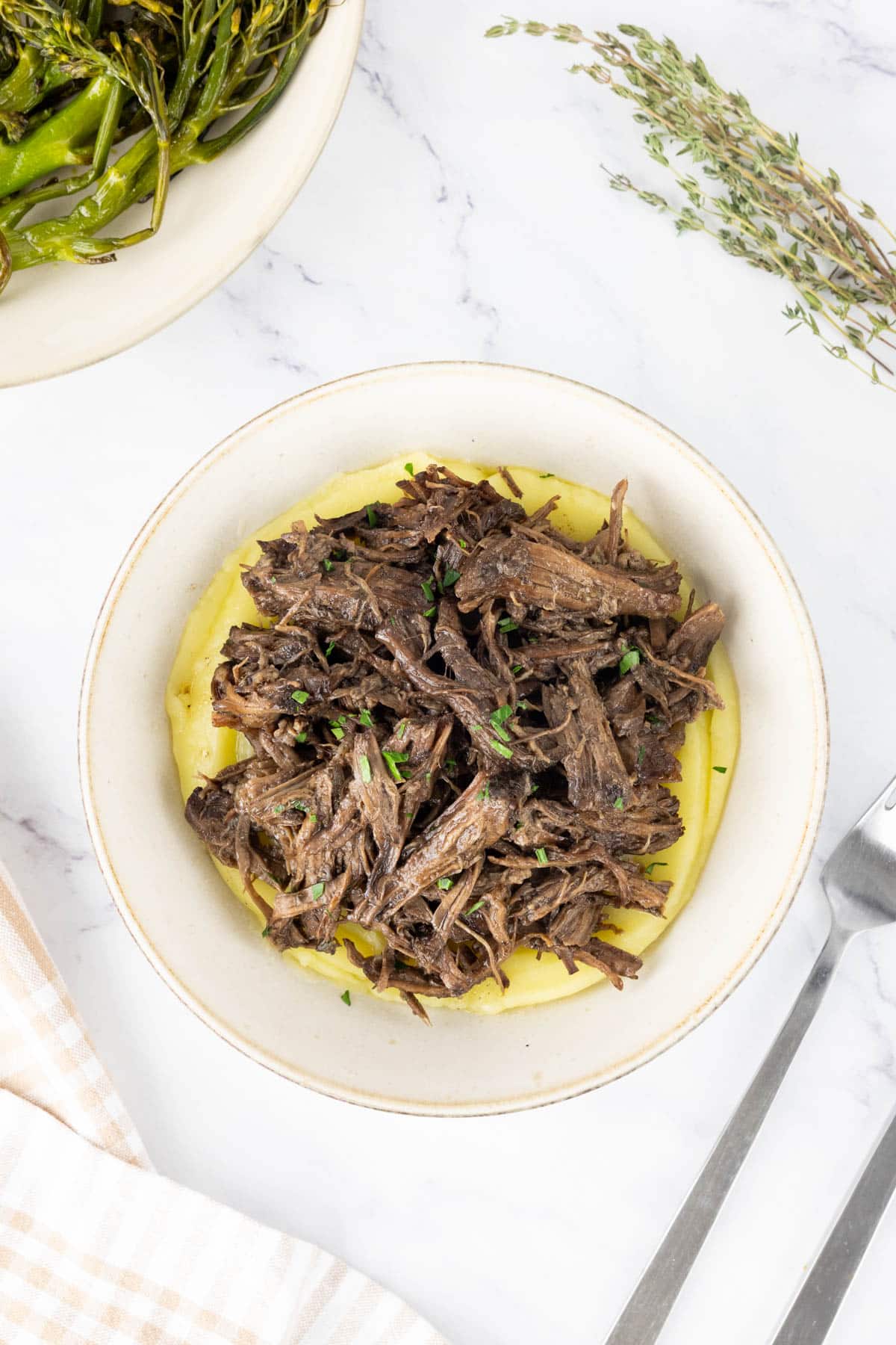 Shredded beef served with mashed potatoes and tender stem broccoli. 
